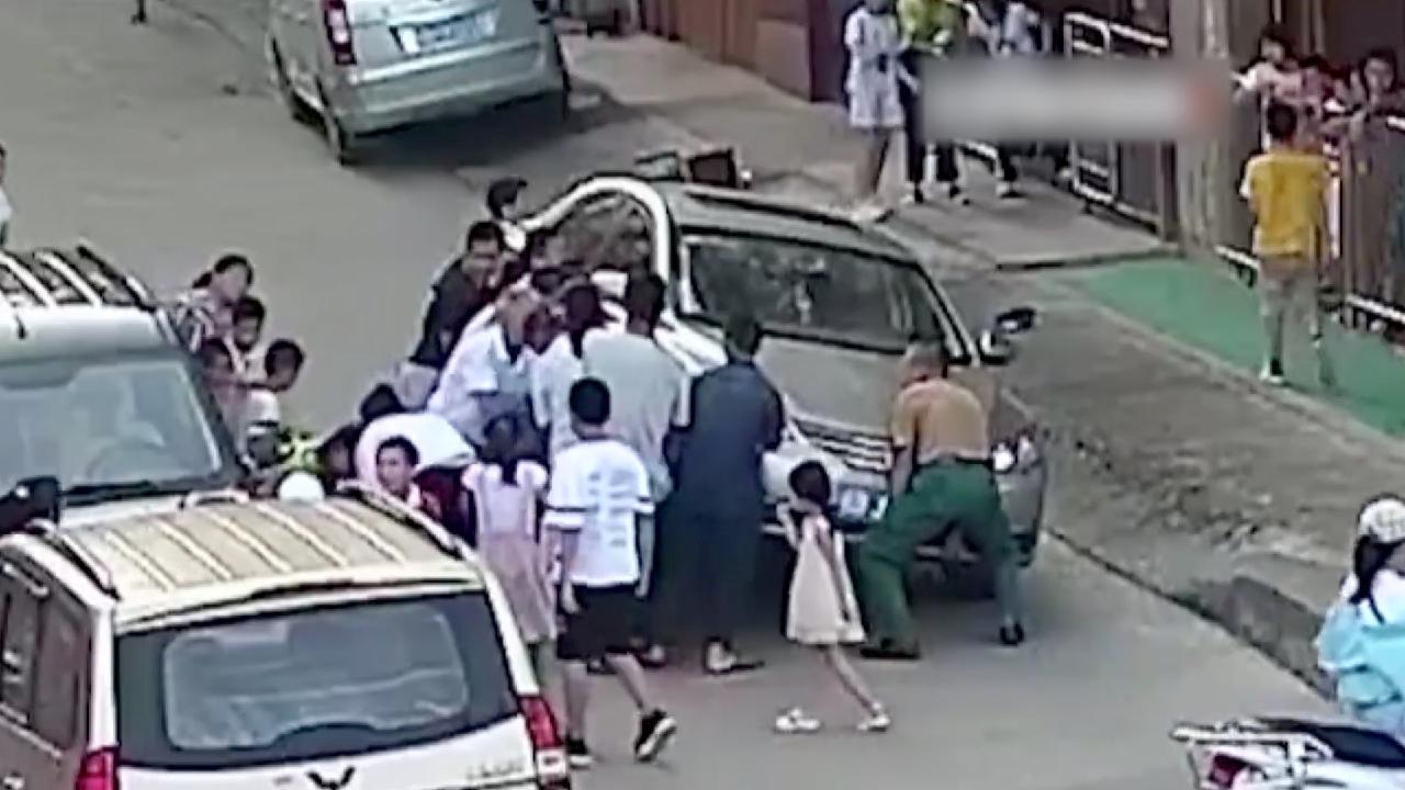 Passersby lift car to free trapped child in south China - CGTN